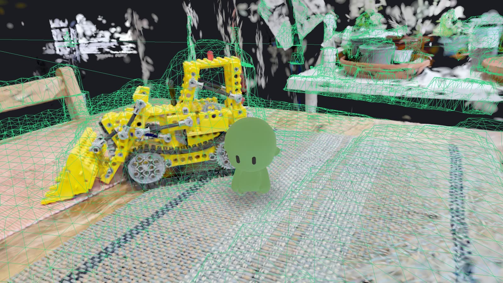 The collision mesh drawn as a green wireframe over the bulldozer and table in the Kitchen scan